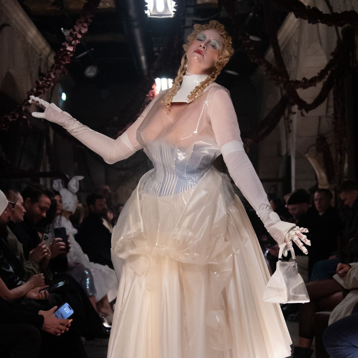 Perhaps the most show-stopping moment of all, however, was the appearance of the actress Gwendoline Christie, who took to the runway to close the show in a sheer, corseted gown overlaid with tinted rubber that wouldn't have looked out of place in a Tim Burton film. The look was accessorised with white stockings, heels and bag, as well as doll-like make-up with a gothic slant: think exaggerated blonde curls, glassy skin and smudged eyeshadow.