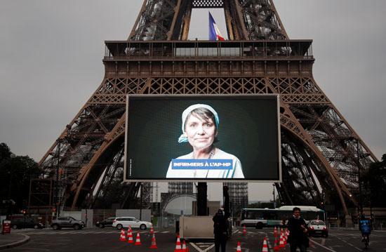 صور أبطال محاربى كورونا على شاشات عملاقه بمحيط "برج إيفل" تكريما لهم