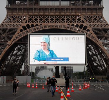 صور أبطال محاربى كورونا على شاشات عملاقه بمحيط "برج إيفل" تكريما لهم