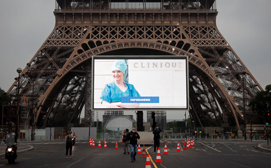 صور أبطال محاربى كورونا على شاشات عملاقه بمحيط "برج إيفل" تكريما لهم