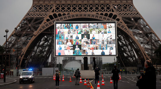 صور أبطال محاربى كورونا على شاشات عملاقه بمحيط "برج إيفل" تكريما لهم