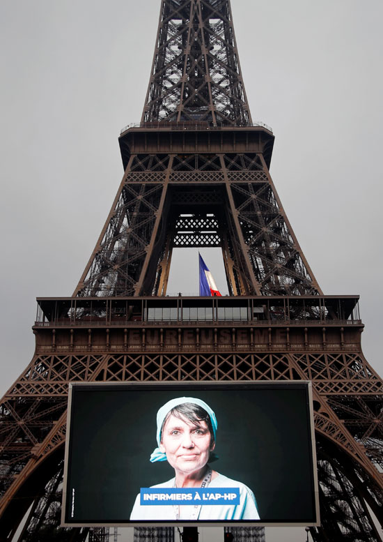 صور أبطال محاربى كورونا على شاشات عملاقه بمحيط "برج إيفل" تكريما لهم
