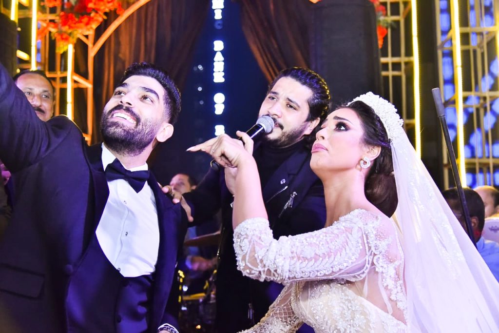 بالصور  .. رنا سماحة وسامر أبو طالب يقدمان "يا أنا يا مفيش" مع تامر حسني ليلة زفافهما بحضور نجوم الأغنية ﻿